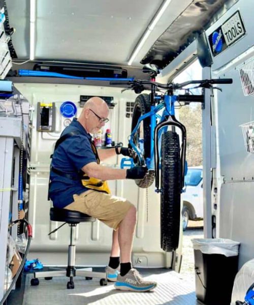 Technicus repareert een fatbike in een mobiele werkplaats, klaar voor avontuurlijke ritten.